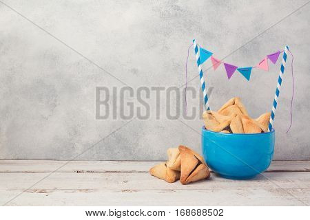 Purim celebration concept with hamantaschen cookies over rustic background.