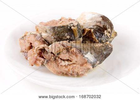 Canned pilchard fish on a plate isolated on white background.