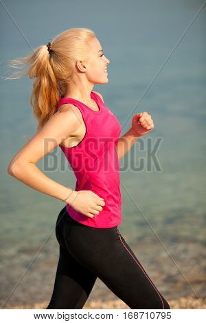 jogging in th beach - woman runns near sea on early summer morning