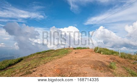 Tourists on the mound and blue sky with white cloud above high mountain at viewpoint of Phu Chi Fa Forest Park in Chiang Rai Province Thailand 16:9 wide screen