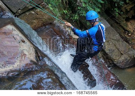 Beaufort,Sabah,Malaysia-Jan 28,2017:Adventure man rappelling Jempangah waterfall in Beaufort,Sabah,Borneo.Waterfall Abseiling activity adventure getting famous in Sabah,Borneo,Malaysia