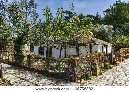 Old stone house and violet flowers in village of Aliki, Thassos island, East Macedonia and Thrace, Greece