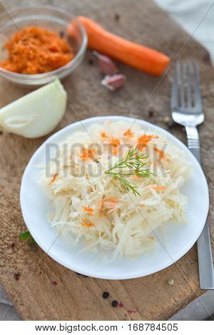 Ferment cabbage with carrot on a white plate.