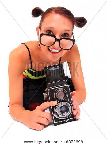 Fotografo di giovane donna con fotocamera su uno sfondo bianco.