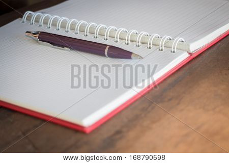 Pen and noteboook paper on wooden table stock photo