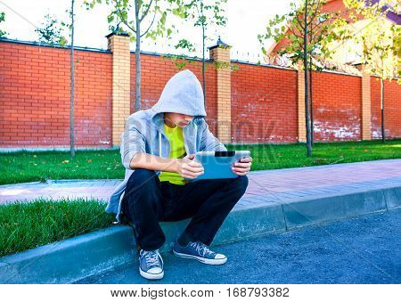 Sad Teenager with Tablet Computer on the Street
