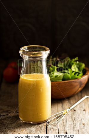 Homemade honey mustard salad dressing in glass bottle