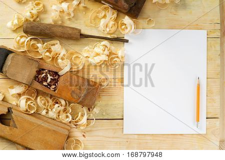 White sheet on wooden table for carpenter tools with sawdust. Copy space. Top view.