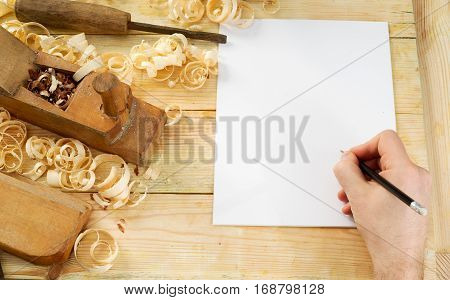 White sheet on wooden table for carpenter tools with sawdust. Copy space. Top view.