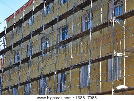 Energy efficiency house wall renovation for energy saving. Exterior house wall heat insulation with mineral wool building hospital under construction.