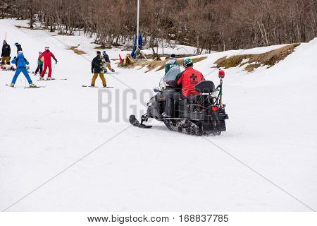 February 4 2017. A paramedic rides on a snowmobile to a snowboarding tourist injured in an accident. Gokase ski area Miyazaki Japan.