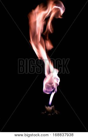 A bright splash of a candle flame on a dark background.