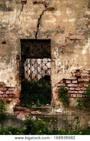 The window in the wall of the old church with wrought-iron grating.