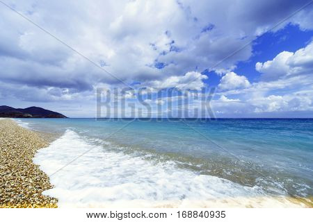 Beautiful sea paradise beach on a background of blue sky with clouds.