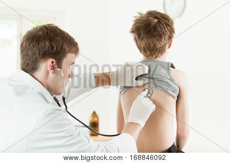 Male Doctor Listening Boy Back With Stethoscope