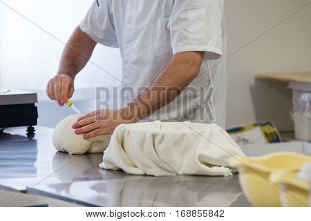 Kneader cutting the yeast base over a worktable