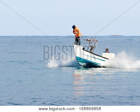 Nahariyya Israel - February 04 2017 : Fishermen in overcast weather patrol on boat and looking for fish near the shore of Nahariyya Israel
