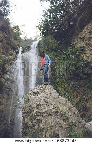 Traveler standing on a rock near waterfall in azad Kashmir Pakistan