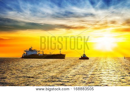 Sun setting at the sea with tanker ship.