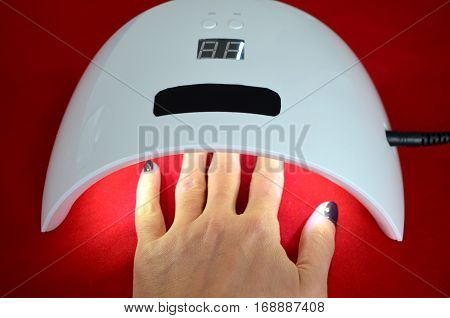 Nail gel salon. Beautiful woman hand and lamp UV  for nails UV with timer