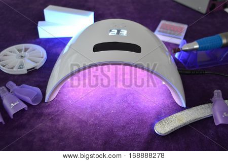 Nail gel salon. Beautiful woman hand and lamp UV  for nails UV with timer