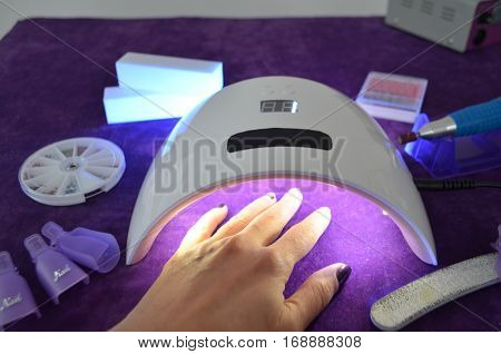 Nail gel salon. Beautiful woman hand and lamp UV  for nails UV with timer