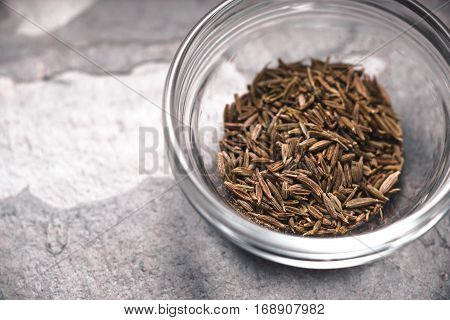 Glass bowl with cumin on slate right horizontal