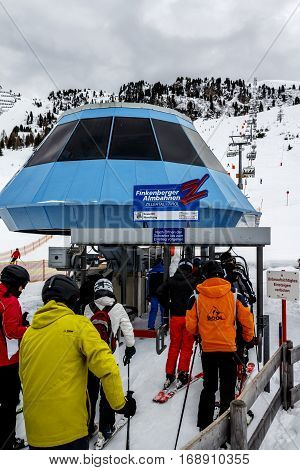 HINTERTUX, AUSTRIA - MARCH 29, 2015: The ski lift Nordhangbahn at the Horberg mountain in Tyrol Austria with people in the queue for a lift to the mountaintop