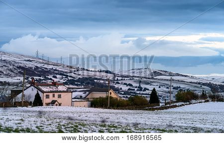 Houses and peaks covered by snow in Greater Manchester England.