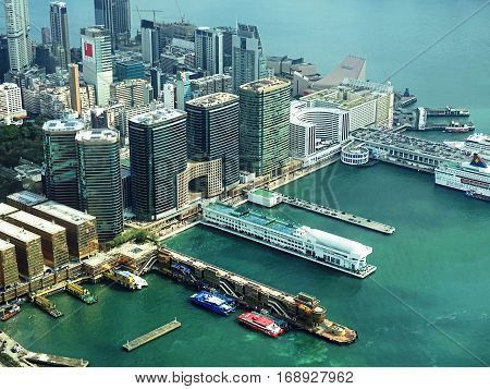 Hong Kong, China - February 13, 2016: View over the district Tsim Sha Tsui in Hong Kong, China. A cruise ship of the shipping company Star Cruises and ferries moored at the piers.