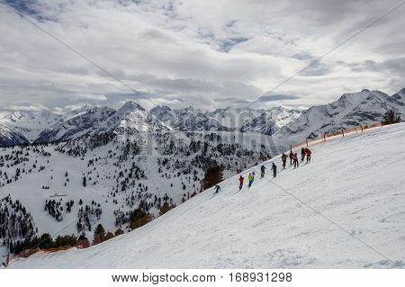 Group of people waiting prior downhill skiing on a black piste at the Horberg mountain in Tyrol Austria