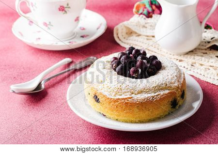 Blackcurrant cake on pink background with tea, horizontal