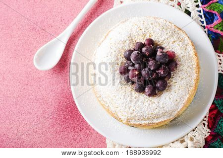 Blackcurrant cake on pink background with tea, horizontal, top view