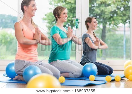 Young women doing  yoga during postnatal recovery lesson