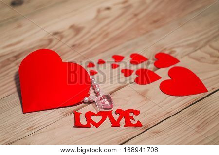 Hearts flowers ribbons on a wooden light background
