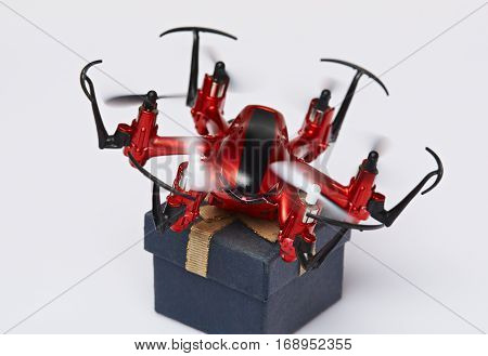 Carrying package with fly drone isolated on white background. Fast delivery via air post