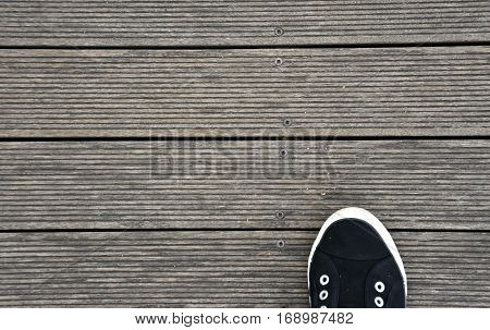 Black and white Shoes stand on old wooden pier floor. Wood pier abstract texture of a natural gray. View of old weathered deck wooden board. Horizontal wood background texture.