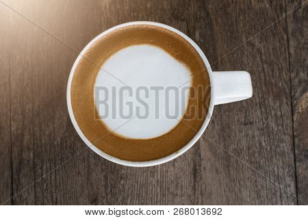 Hot Coffee With Foam Milk On Wooden Background.