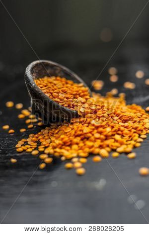 Close Up Of Raw Masur Dal Or Masoor Lentils Or Pink Lentils In A Black Colored Clay Bowl On Wooden S