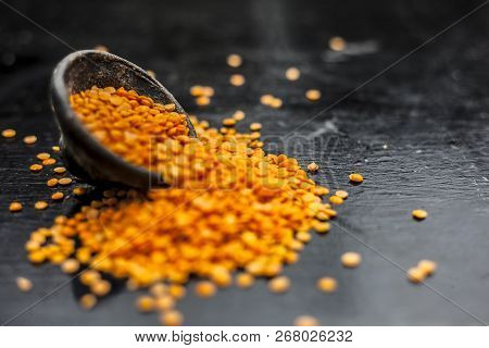 Close Up Of Raw Masur Dal Or Masoor Lentils Or Pink Lentils In A Black Colored Clay Bowl On Wooden S
