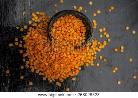 Close Up Of Raw Masur Dal Or Masoor Lentils Or Pink Lentils In A Black Colored Clay Bowl On Wooden S