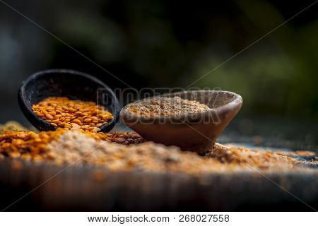 Close Up Of Raw Pink Lentils In A Clay Bowl On Wooden Surface With Its Powder.