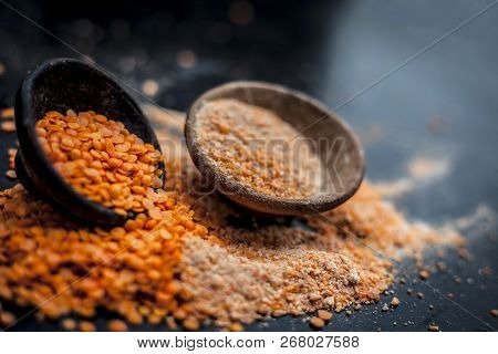 Close Up Of Raw Pink Lentils In A Clay Bowl On Wooden Surface With Its Powder.