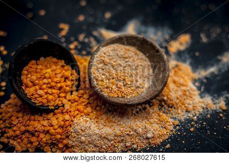 Close Up Of Raw Pink Lentils In A Clay Bowl On Wooden Surface With Its Powder.