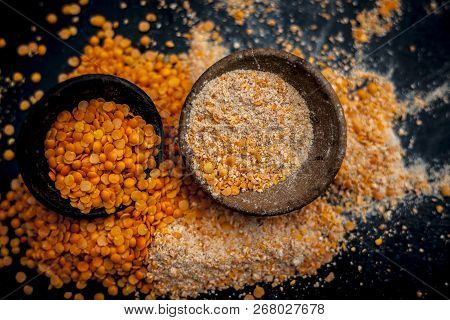 Close Up Of Raw Pink Lentils In A Clay Bowl On Wooden Surface With Its Powder.