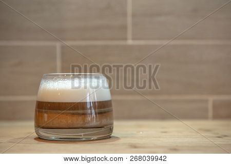 Multilayer Coffee Or Cappuccino In A Glass Cup On Wooden Table