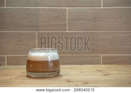 Multilayer Coffee Or Cappuccino In A Glass Cup On Wooden Table