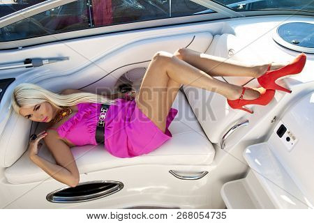 Beautiful Young Blond Woman In Pink Dress On Boat, Summer Holiday. Luxurious Life.
