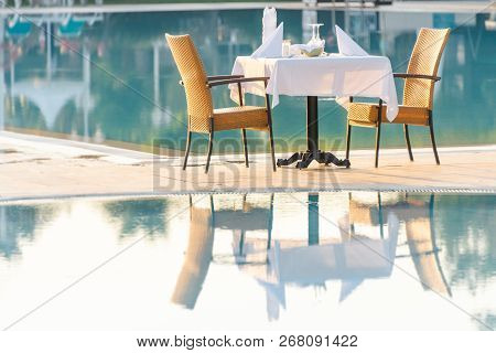 Chairs And Table Near Pool At Hotel Restaurant. Cutlery And Napkings On Tables. Resort Life On Holid