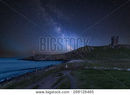 Stunning Vibrant Milky Way Composite Image Over Landscape Of Dunstanburgh Castle On Northumberland C